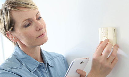 lady adjusting thermostat