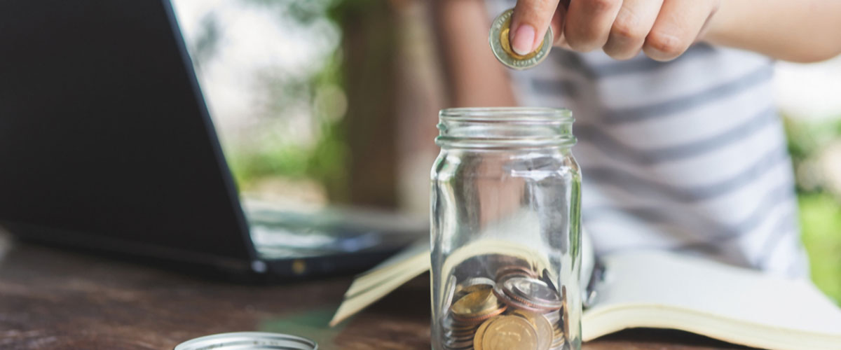 Woman adding money to her emergency fund jar