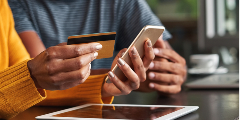 Couple looking at credit card and phone