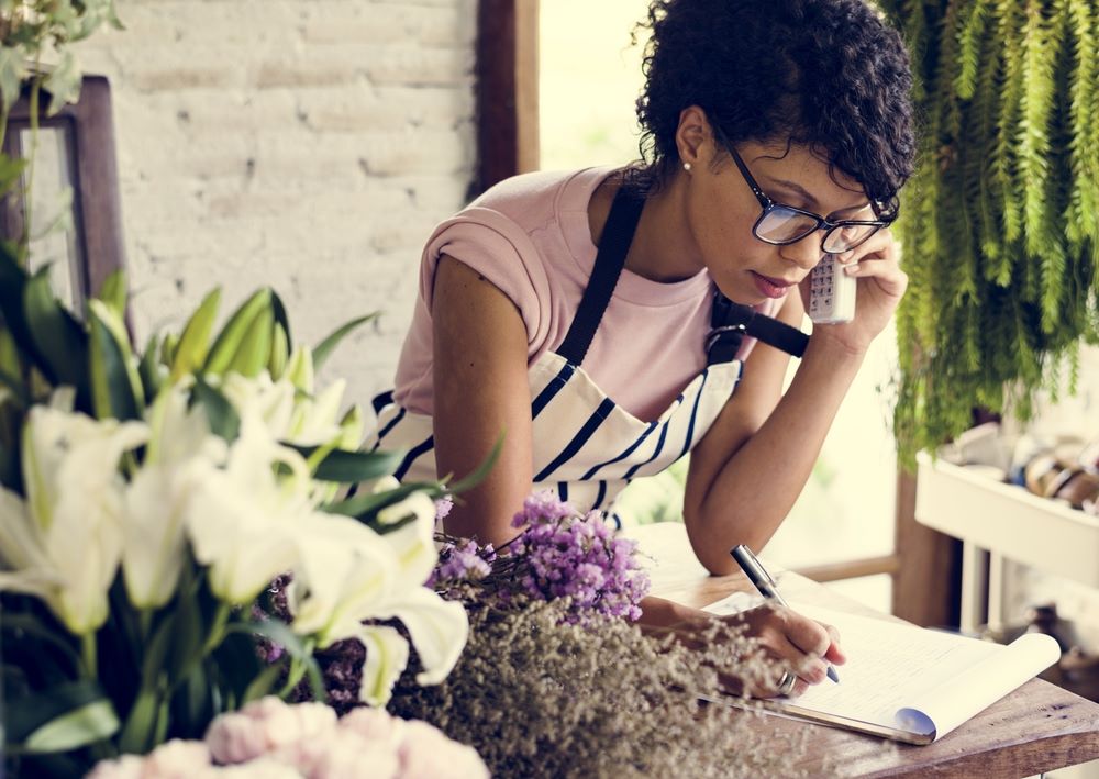 Flower Shop Owner On The Phone Taking Notes