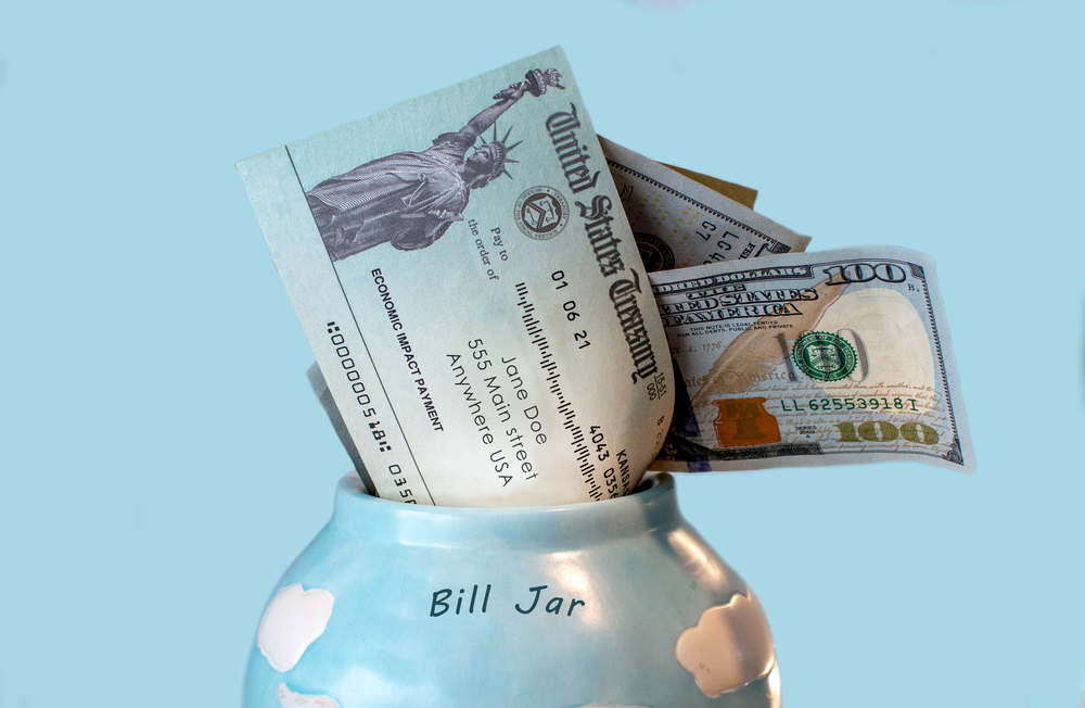 Bill jar filled with money and stimulus check