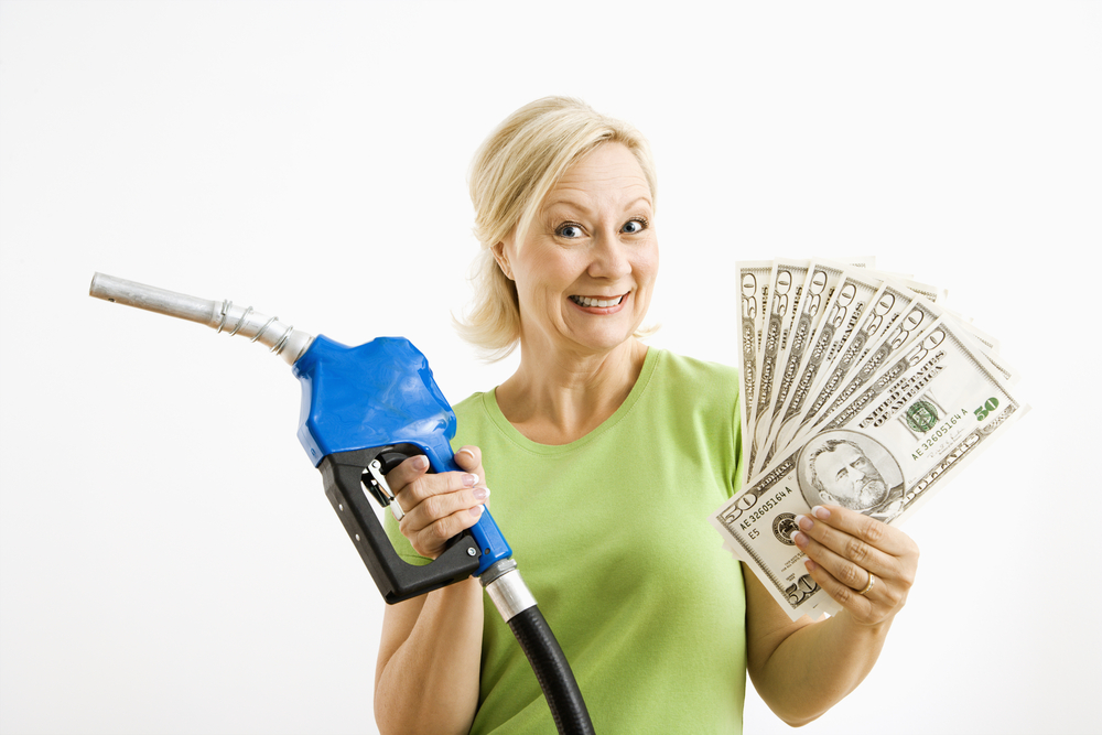 Smiling woman holding gas nozzle and money