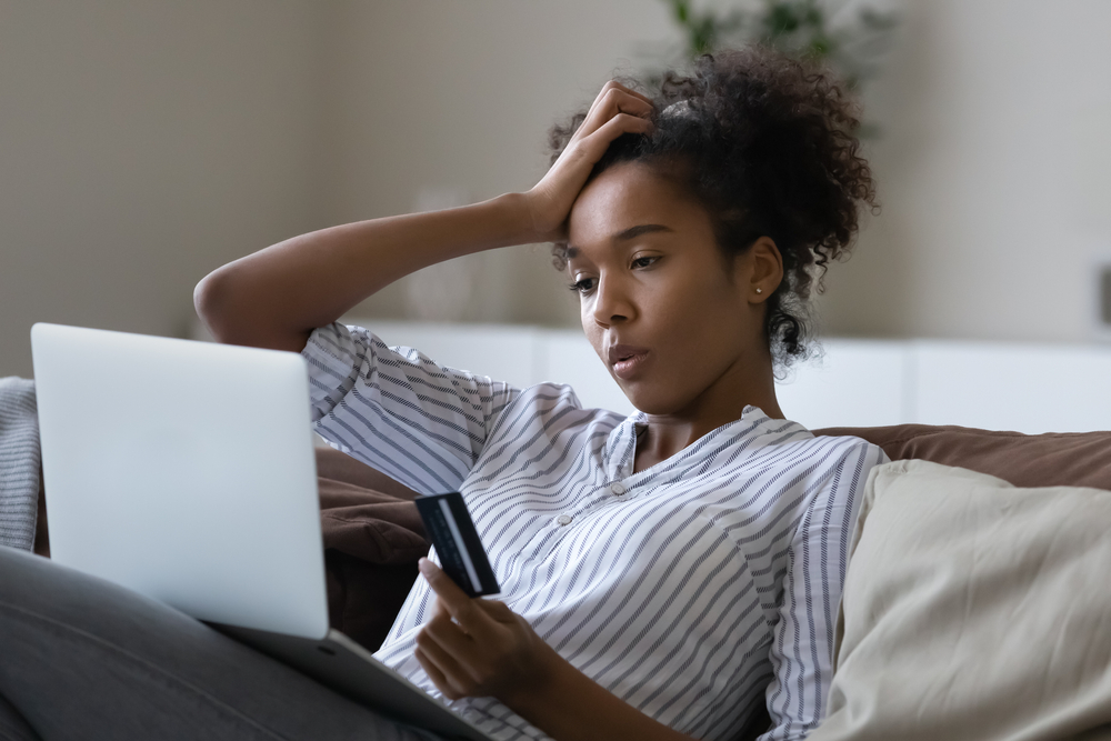 stressed women on laptop holding a credit card