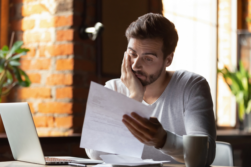 Confused young man reading a document