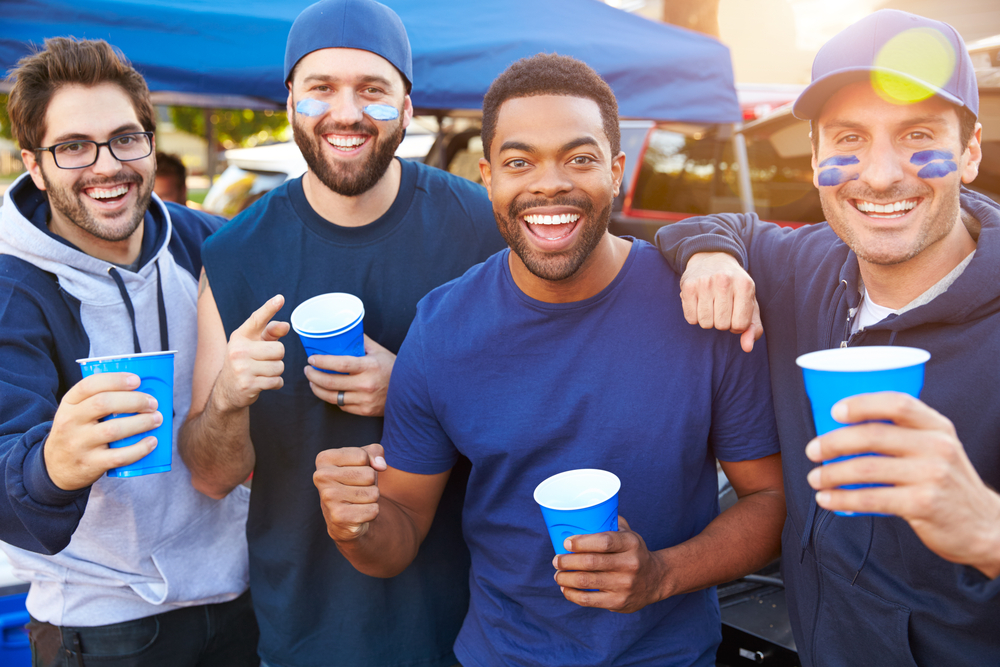 Enthusiastic group of male football fans tailgating.