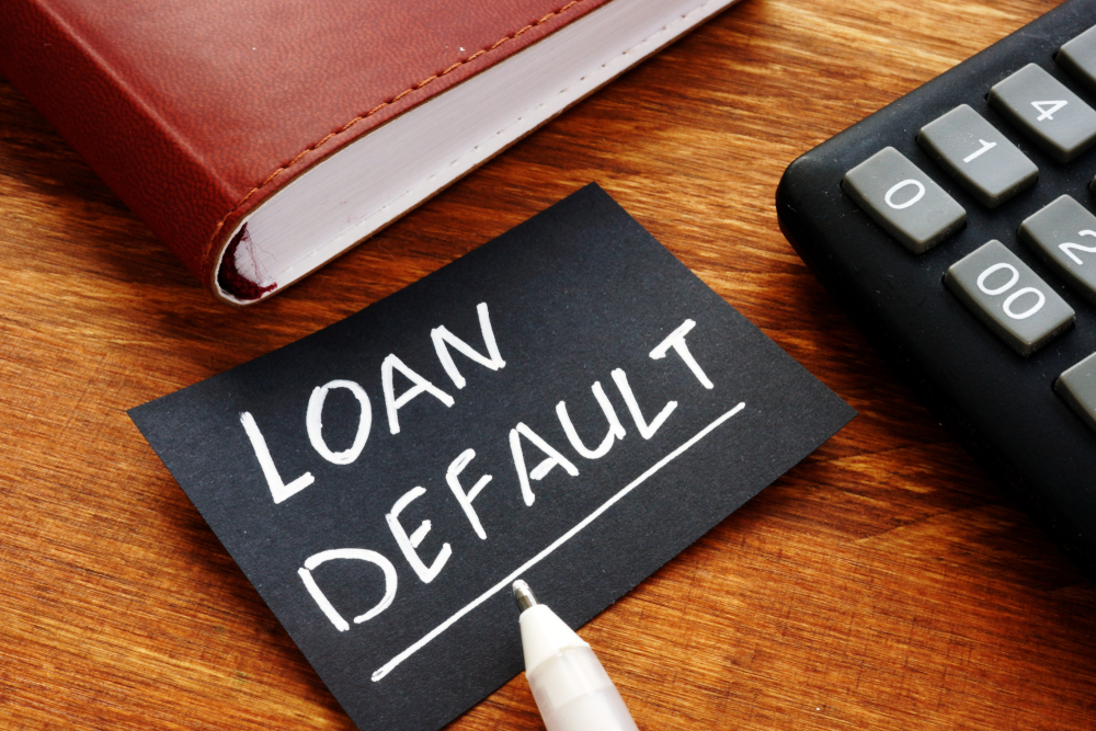 “Loan default” written in white ink on black paper.