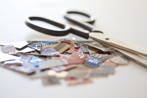 Credit cards cut into pieces laying next to scissors