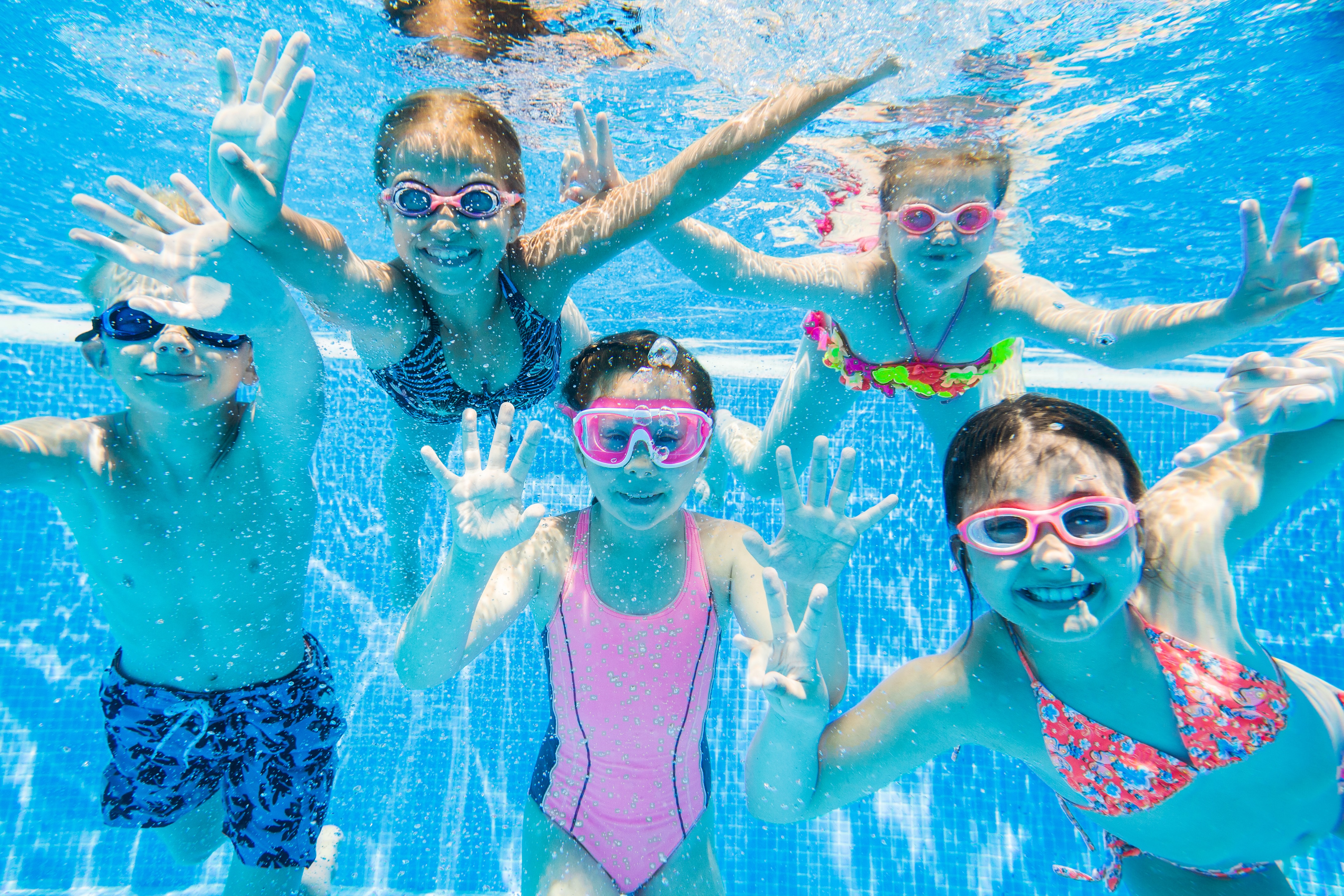 Kids underwater playing in a pool