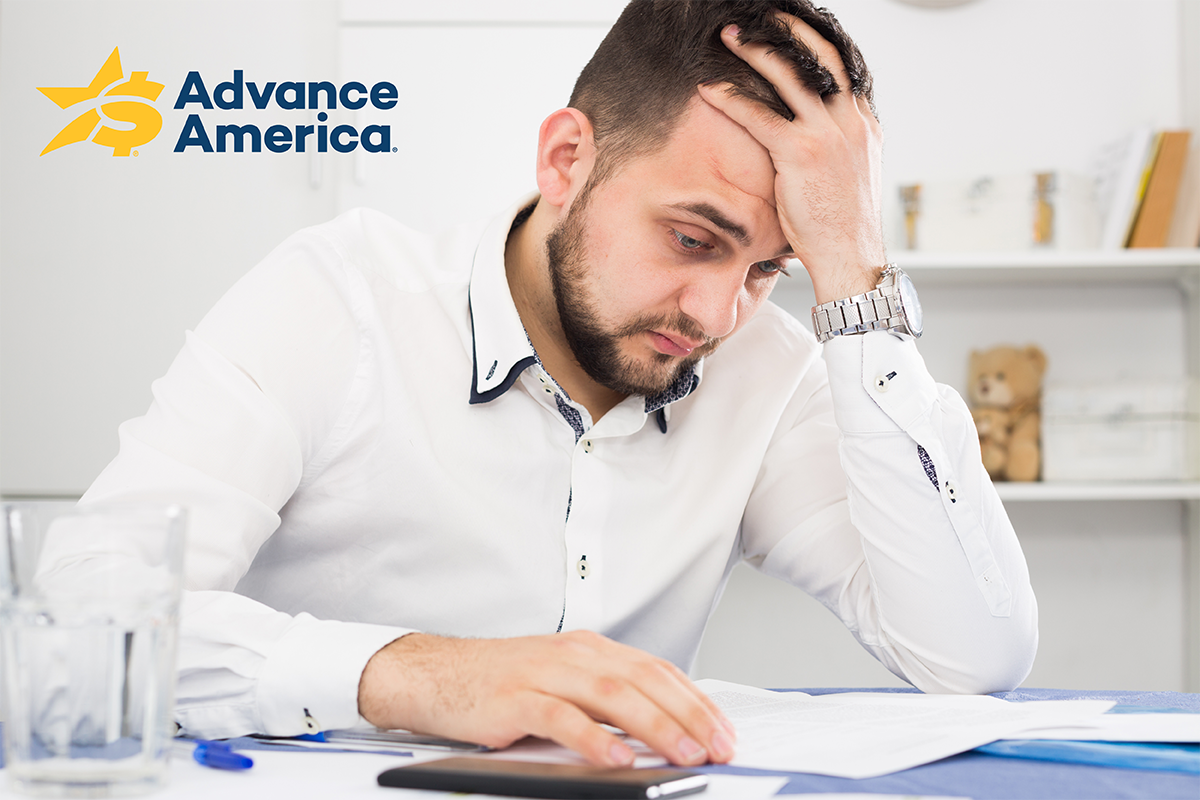 stressed man looks over bills
