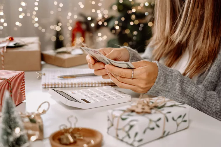 woman counting money with holiday decor