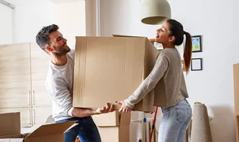 couple moving boxes into new home