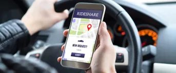 man looking at his rideshare app on his phone