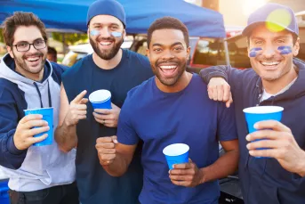 Enthusiastic group of male football fans tailgating.