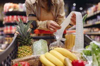 woman grocery shopping looking at her receipt