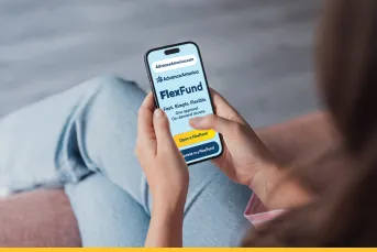 A person sitting down and holding a smartphone displaying the Advance America FlexFund page, with the tagline "Fast. Simple. Flexible. One approval. On-demand access." and a yellow "Open a FlexFund" button.