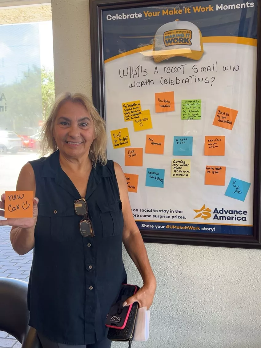 Woman holding a card in front of board full of cards