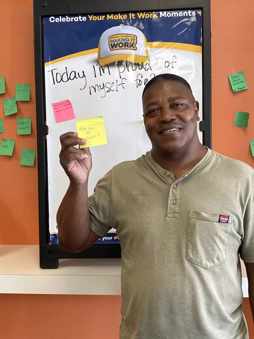 man holding post it note