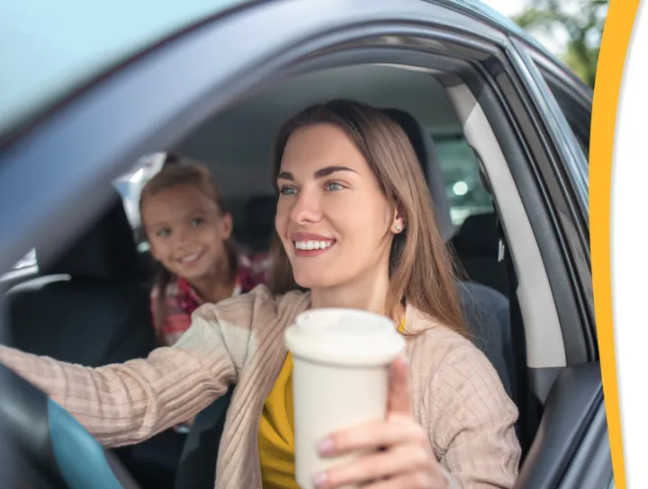 person driving car with child in back seat